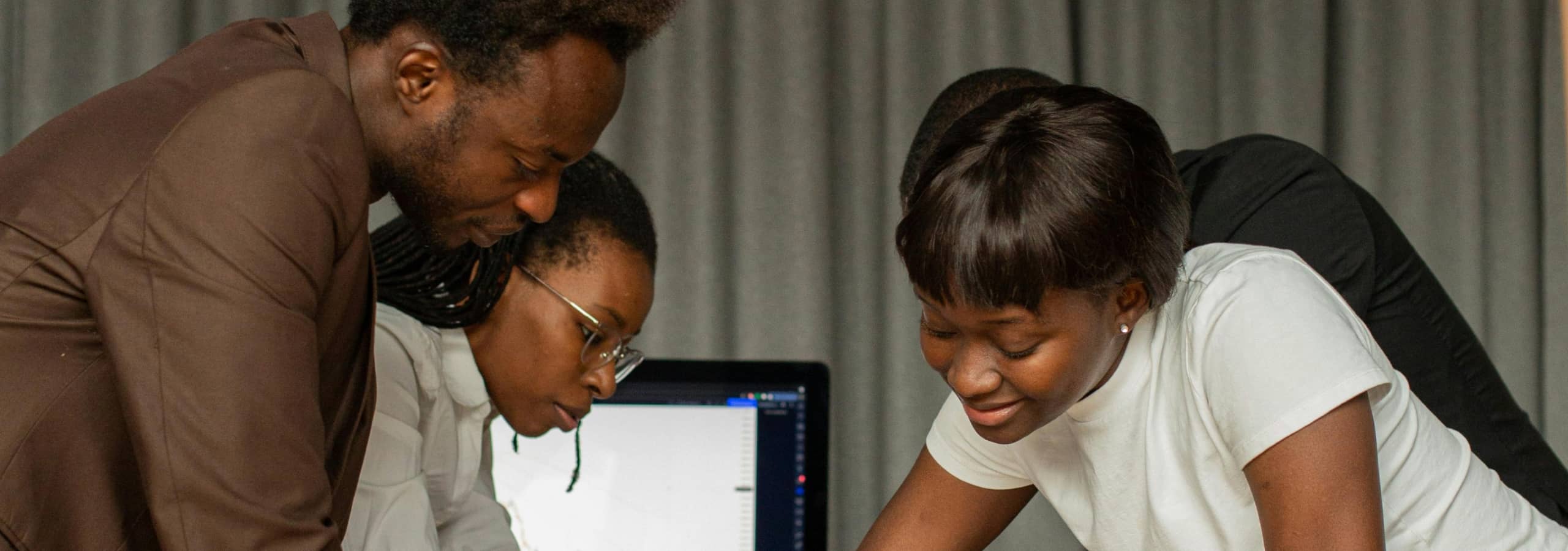 Nigerian business owner smiling at computer