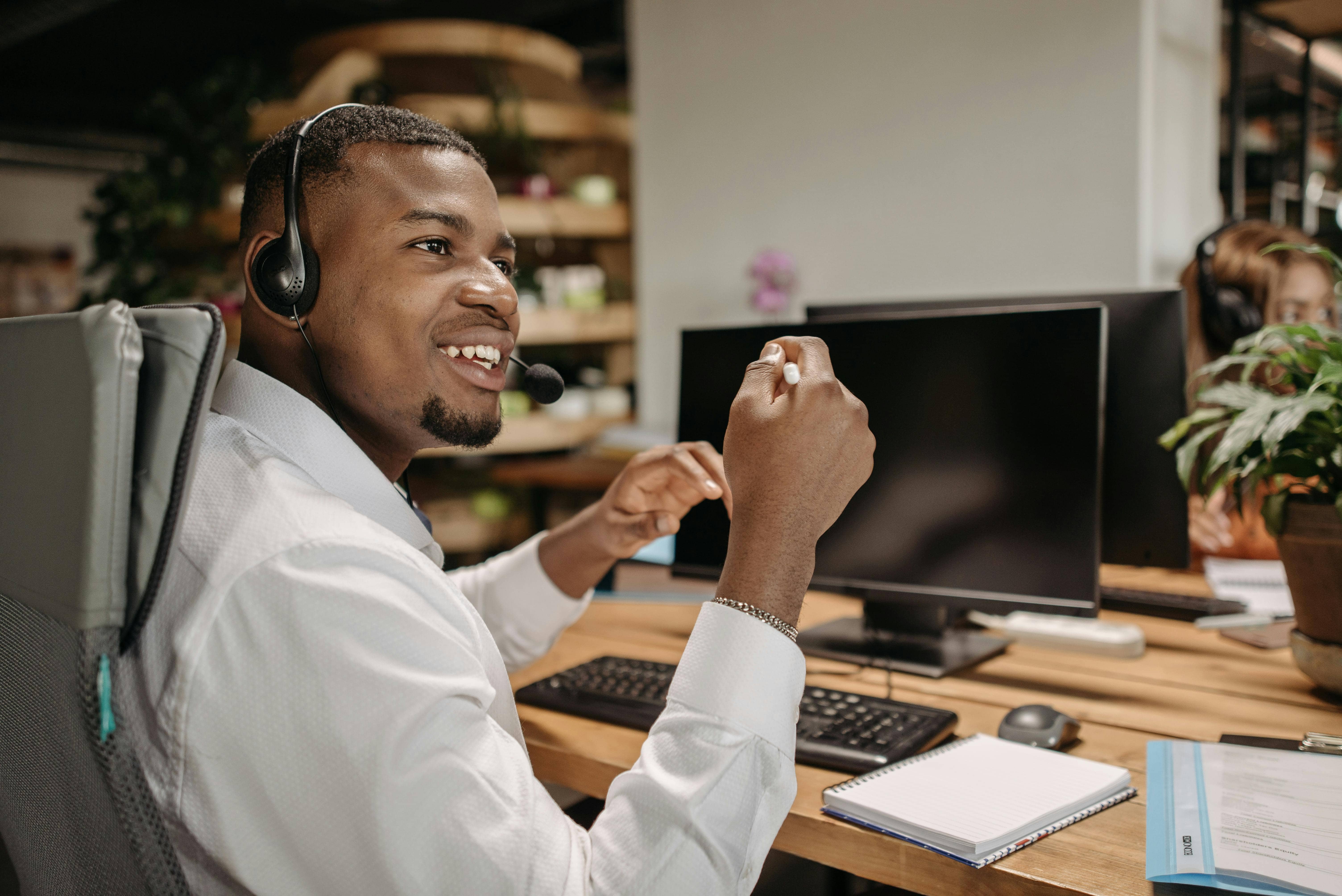 Nigerian business owner smiling at computer